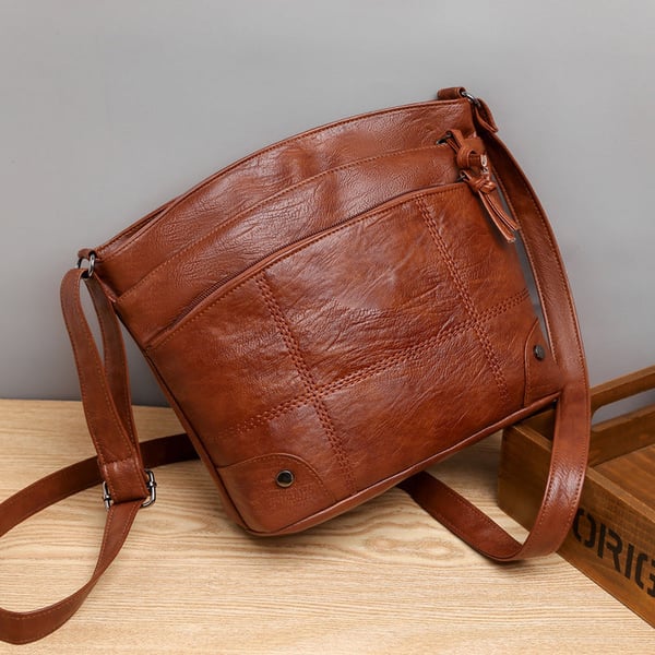 Skuldertaske i blødt læder med flere lommer og stor kapacitet