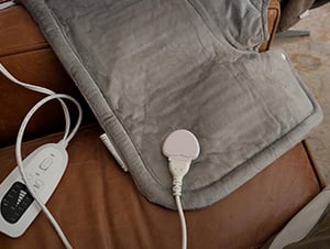 Heating pad draped over a chair