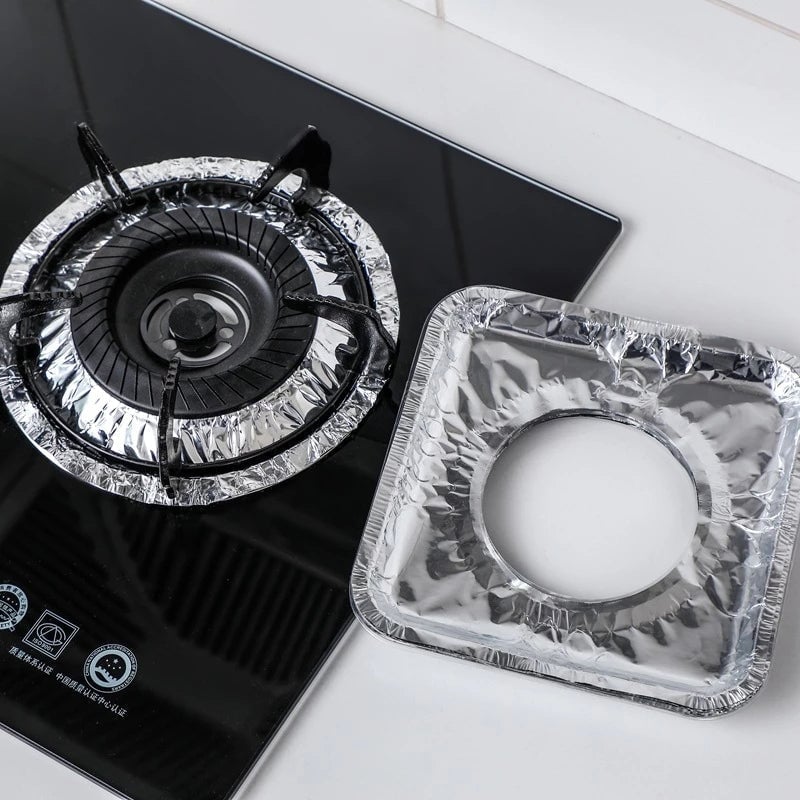Aluminum foil gas stove pad with a central burner opening