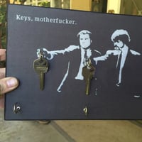 Houten sleutelhanger aan de muur